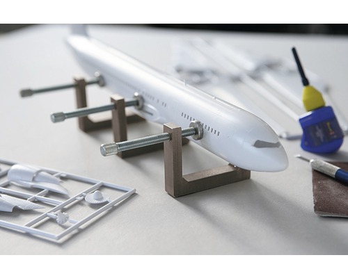 Modellflugzeug im Bau mit Werkzeugen und Klebstoff