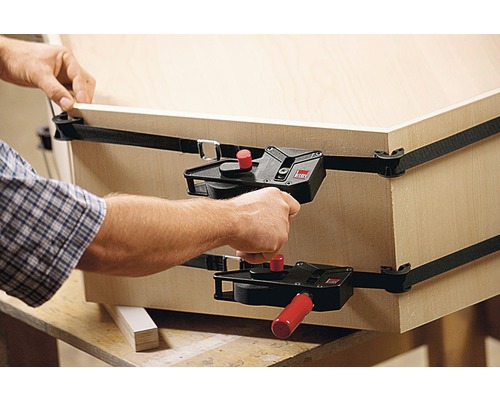 Une personne fixe une pièce en bois avec une sangle de serrage de Bessey