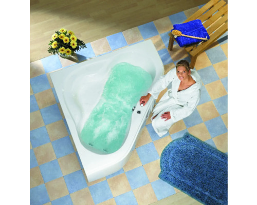 Femme en peignoir à côté d''une baignoire d''angle remplie avec fonction de jacuzzi dans une salle de bain