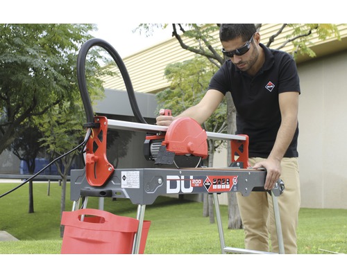 Mann bedient Fliesenschneider Rubí DU 200 EVO auf einem Rasen