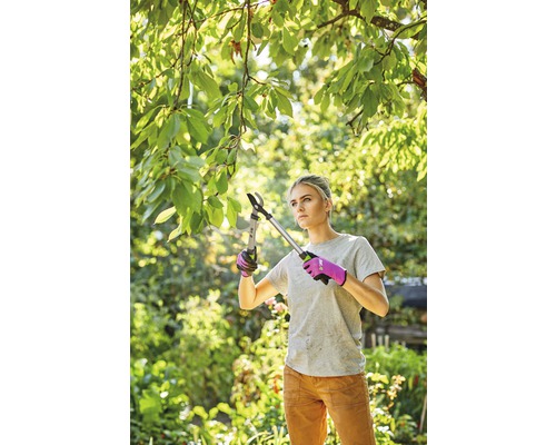 Frau schneidet Äste mit einer Astschere im Garten