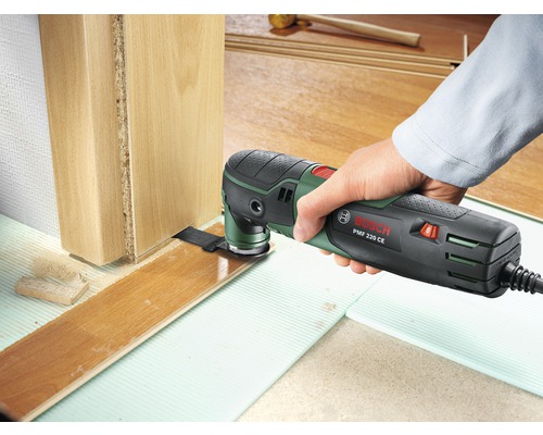 Outil multifonction Bosch PMF 220 CE en cours d’utilisation pour ajuster le stratifié à un dormant de porte