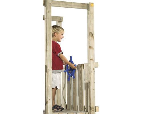 Un enfant joue avec un volant bleu dans une tour de jeu en bois.