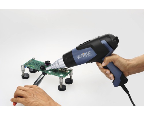 Pistolet à air chaud lors du soudage d''une carte de circuit imprimé avec une pince à épiler et un support