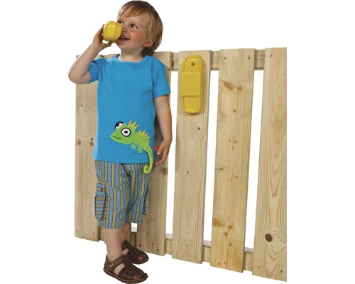 Garçon avec un téléphone jouet près d''une clôture en bois