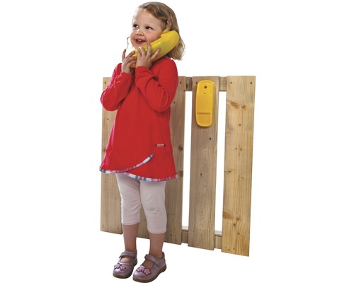 Fille téléphone avec un téléphone jouet sur une clôture en bois