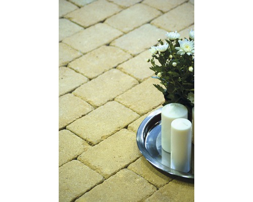 Pflastersteine im Fischgrätenmuster mit Kerzen und Blumenarrangement