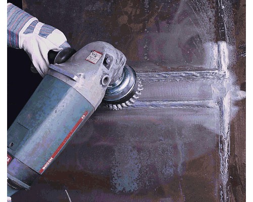 Une personne utilise une brosse métallique sur une meuleuse d''angle pour travailler le métal.