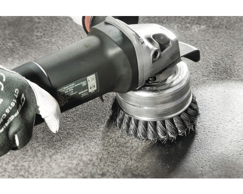 Accessoire de brosse métallique sur une meuleuse lors du nettoyage d''une surface