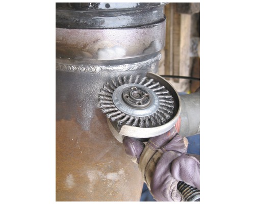 Brosse métallique utilisée sur une surface de tuyau.