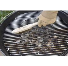 Eine Grillbürste reinigt einen Grillrost.