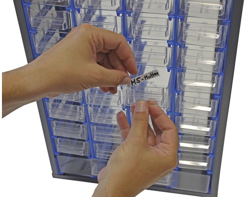 Person beschriftet Schublade eines Sortimentskasten