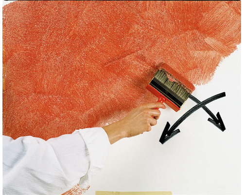 Une personne peint un mur avec une grosse brosse pour créer une technique de peinture spéciale.