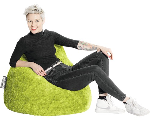Une femme assise sur un pouf vert.