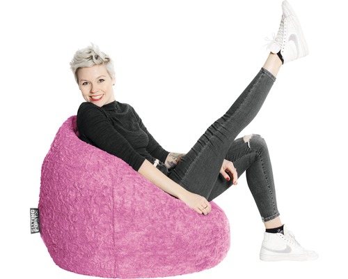 Femme assise confortablement dans un pouf rose