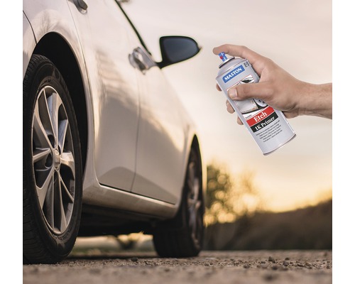 Une main tient un aérosol Maston Etch 1K Primer devant une voiture.