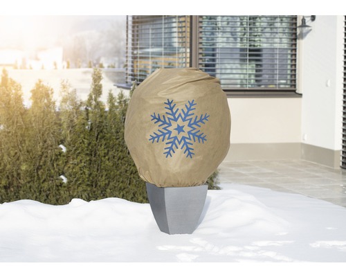 Pot de fleurs avec housse de protection hivernale et motif de flocon de neige dans le jardin