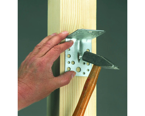 Eckverbinder wird mit einem Hammer an einem Holzbalken befestigt.