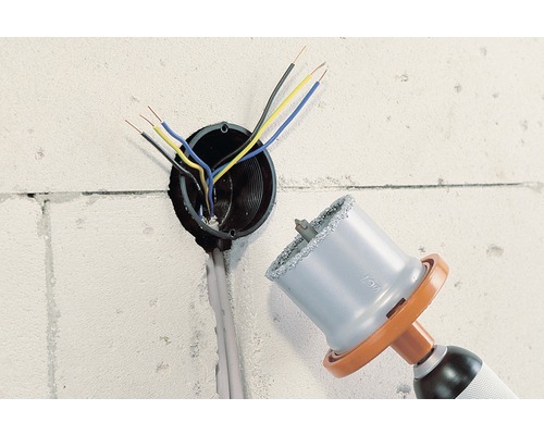 Perceuse avec scie cloche pour percer une prise de courant dans un mur