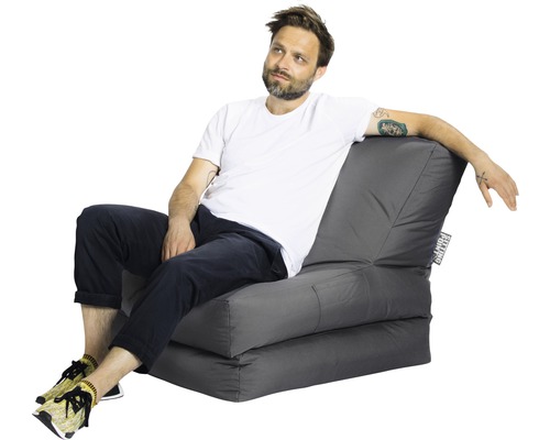 Homme assis sur un fauteuil-lit gris