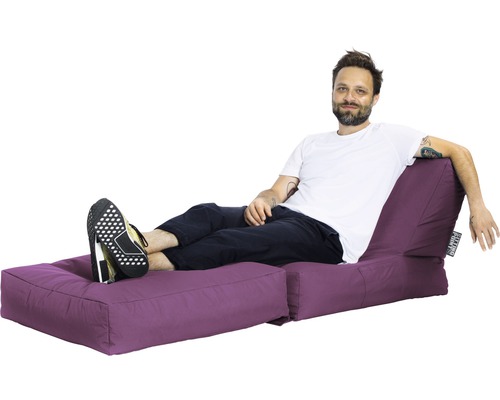 Un homme se détend sur un îlot d''assise violet avec repose-pieds.