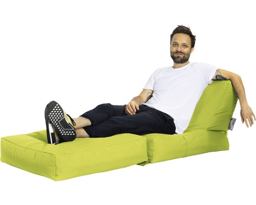 Un homme se détend sur un pouf lumineux avec repose-pieds