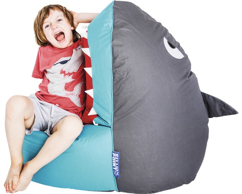 Junge sitzt auf einem Sitzsack in Form eines Hais