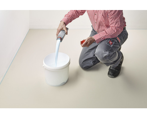 Eine Person giesst eine Flüssigkeit aus einer Flasche in einen Eimer.