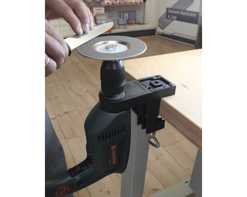 Messer schleifen mit Schleifscheibe und Bohrmaschine an einem Tisch befestigt