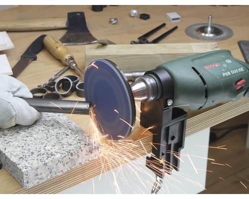 Eine Bohrmaschine mit Schleifscheibe bearbeitet ein Metallstück, Funken fliegen.