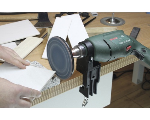 Bohrmaschine mit Schleifscheibe und Werkstücken auf einem Tisch