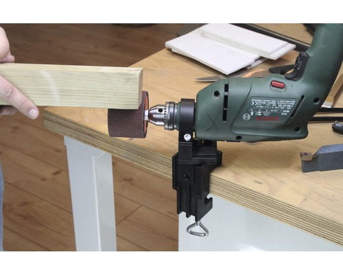 Bohrmaschine mit Schleifzubehör und Werkstück auf einer Werkbank