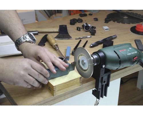 Werkbank mit Werkzeugen und Person beim Werkzeugschleifen