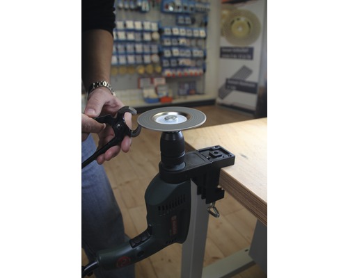 Eine Bohrmaschine ist an einer Werkbank befestigt und schleift ein Werkzeug.