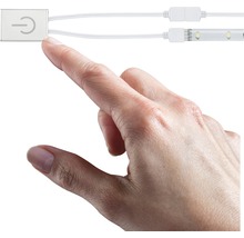 Eine Hand berührt einen Schalter für eine LED-Leuchte.
