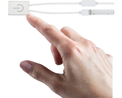 Eine Hand berührt einen Schalter für eine LED-Leuchte.