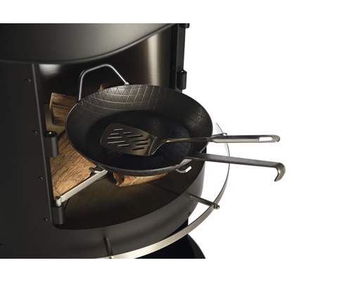 Grill mit Holzkohle, einer Bratpfanne, einem Pfannenwender und Grillbesteck