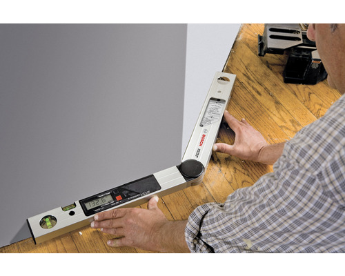 Eine digitale Winkelmesser in Verwendung, zur Messung eines Winkels an einer Wand.