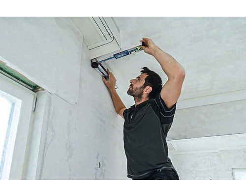 Ein Mann benutzt eine Wasserwaage für Renovierungsarbeiten im Innenbereich.