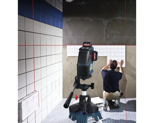 Szene zeigt einen Fliesenleger bei der Arbeit mit einem Linienlaser zur Ausrichtung der Fliesen.