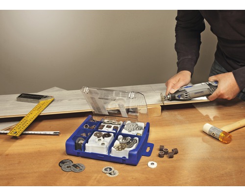 Outil multifonction Dremel en utilisation avec un assortiment d''accessoires sur un établi en bois