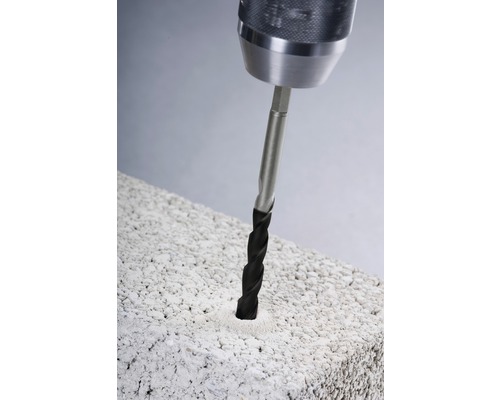 Une perceuse perce un trou dans une pierre.