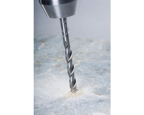 Une mèche hélicoïdale perce un trou dans une surface.