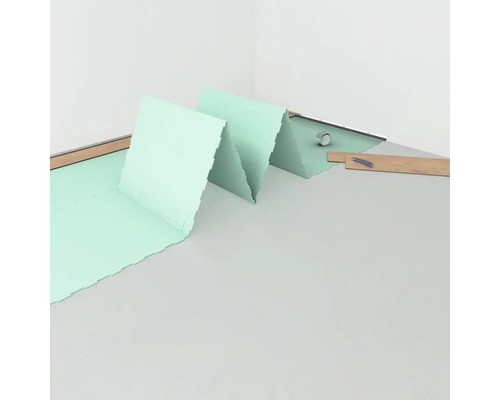 Pose d''une sous-couche isolante dans la pièce, en préparation des travaux de revêtement de sol.