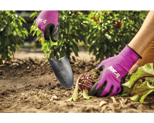 Gros plan d''une personne travaillant dans le jardin avec une truelle de jardinage et des gants de jardinage