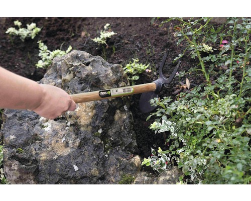 Houe de jardin avec manche en bois utilisée dans un parterre.