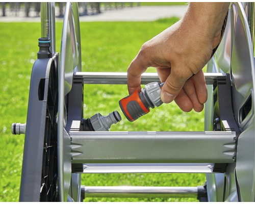 Eine Hand verbindet einen Schlauchverbinder mit einer Schlauchtrommel