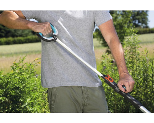 Mann benutzt eine Greifzange im Garten.