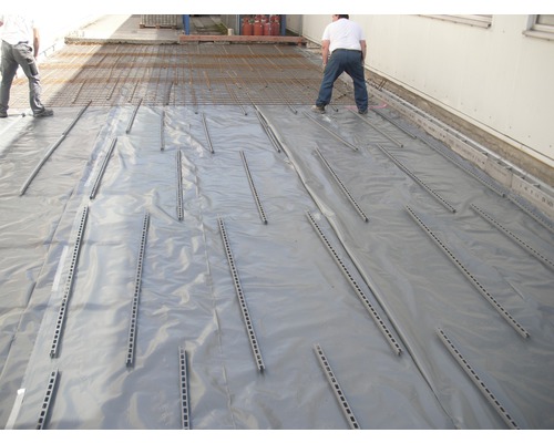 Préparation du sol avec film, entretoises et treillis d''armature pour les travaux de bétonnage