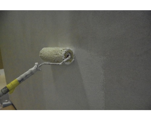 Rouleau à peinture appliquant de la peinture sur un mur.